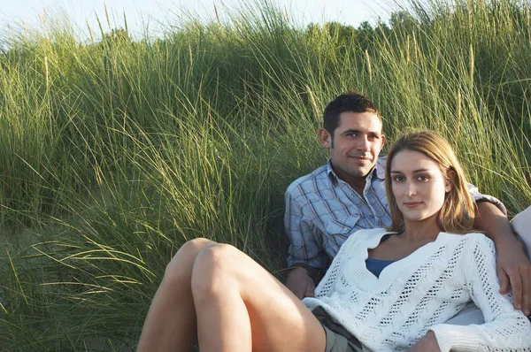 Casal relaxante na grama alta — Fotografia de Stock