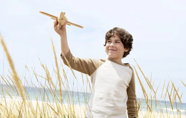 Мальчик стоит летающий игрушечный самолет — стоковое фото