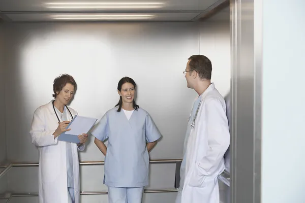 Médicos en Ascensor hablando — Foto de Stock