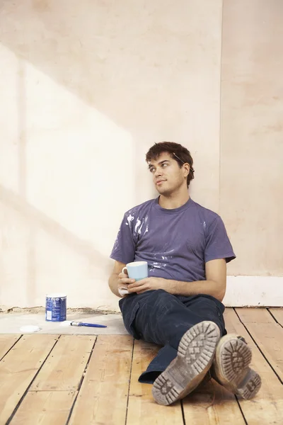 Man sitting on floor of unrenovated room — Stock Photo, Image