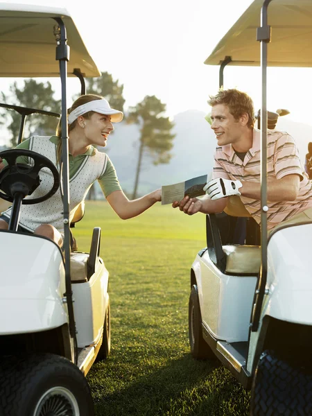 Golfistas sentados em carrinhos de golfe — Fotografia de Stock