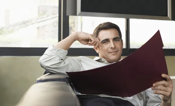 Muž hospodářství složka na sof — Stock fotografie