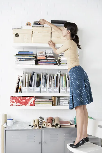 Businesswoman reaching for Shelf — Stock Photo, Image