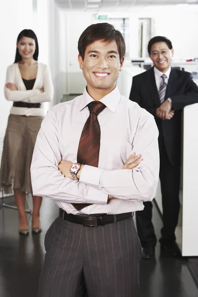 Zakenman staande voor collega 's — Stockfoto