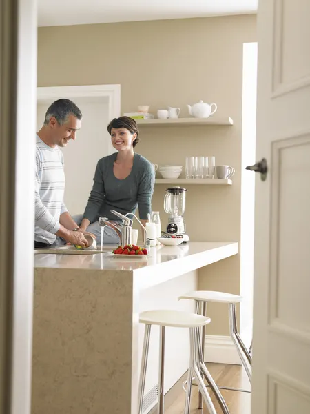 Homme lavage ustensiles avec femme dans la cuisine — Photo