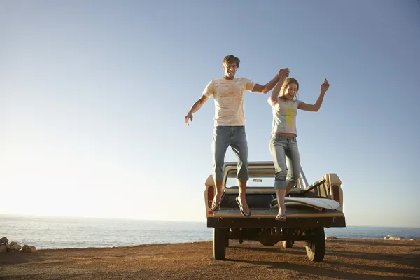 Couple jumping from van — Stock Photo, Image