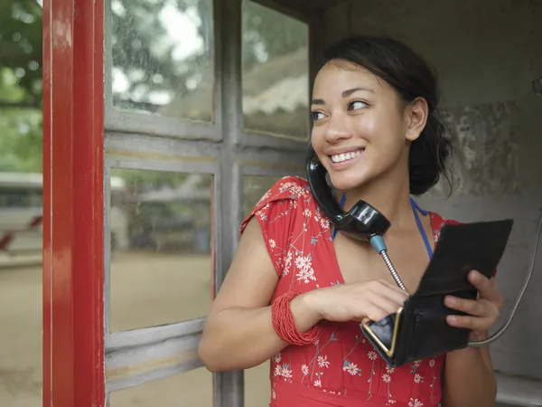 Vrouw met behulp van openbare telefoon — Stockfoto