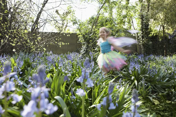 Petite fille courant dans le jardin de fleurs — Photo