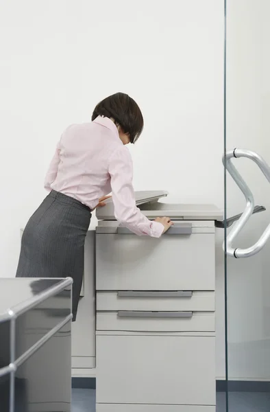 Mujer usando fotocopiadora en oficina — Foto de Stock