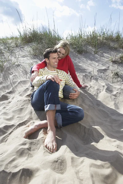 Pareja sentada en la playa — Foto de Stock