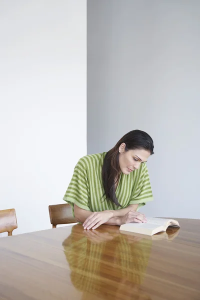 Frau sitzt am Tisch — Stockfoto