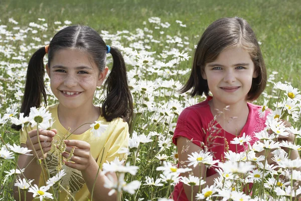 Meisjes staan onder bloemen — Stockfoto