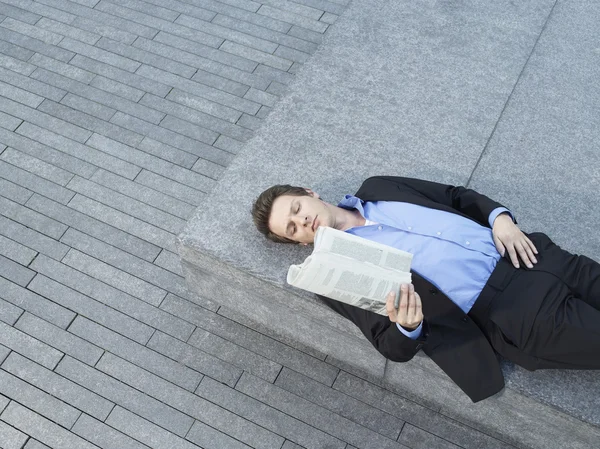 Бизнесмен, лежащий на стене — стоковое фото