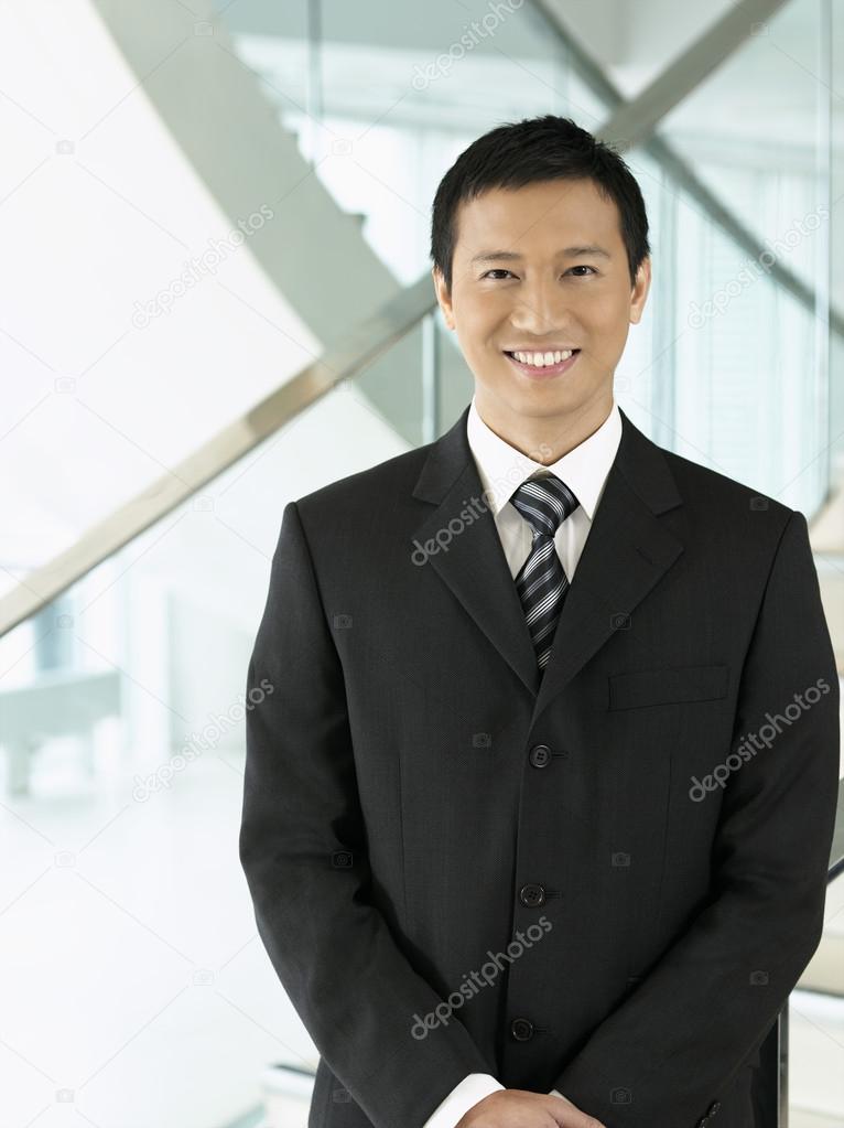 Businessman standing hands clasped