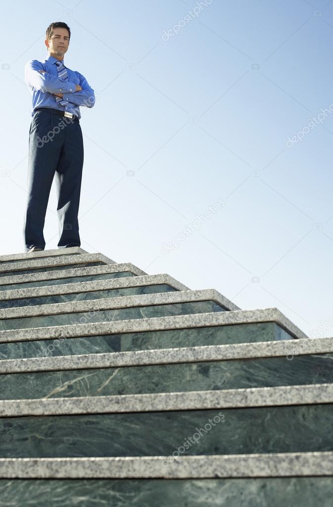 Business man standing at top of steps
