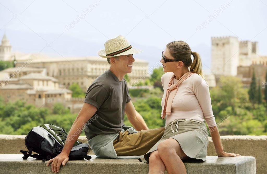 Tourist Couple Relaxing on Wall