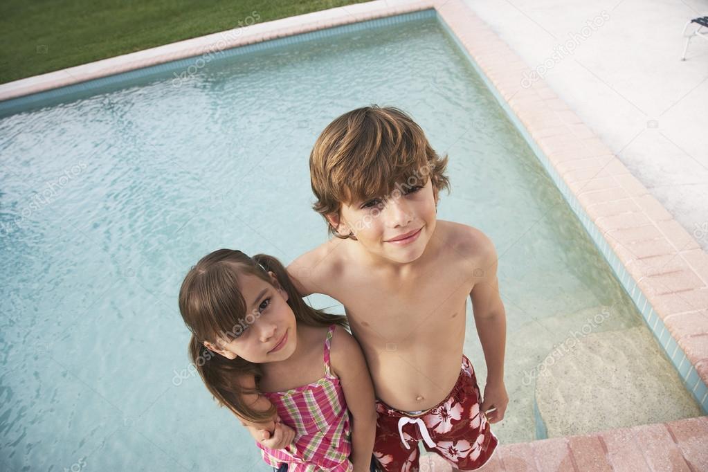 Boy and girl embracing near pool