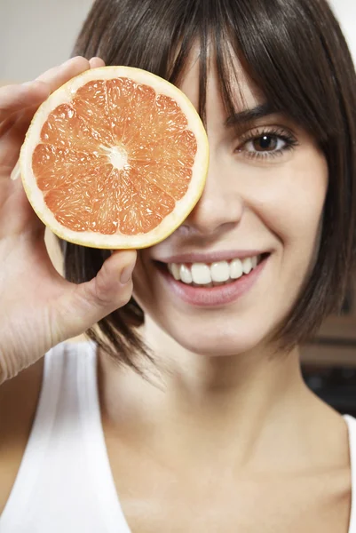 Vrouw met de helft van grapefruit — Stockfoto