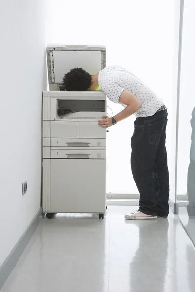 Homem colocando cabeça na máquina de cópia — Fotografia de Stock