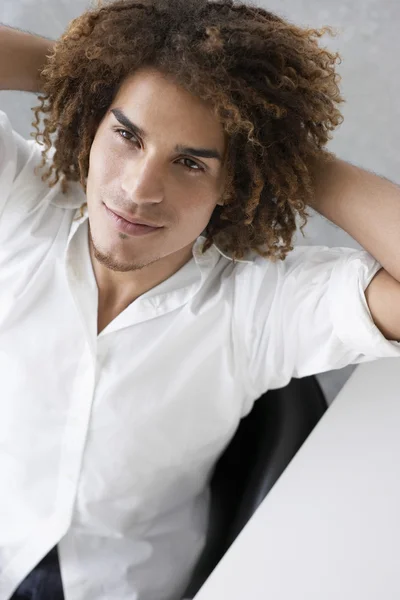 Young man sitting at desk — Stock Photo, Image