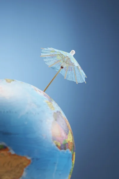 Drink umbrella on globe — Stock Photo, Image