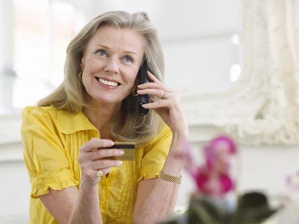 Mujer con tarjeta de crédito y teléfono — Foto de Stock