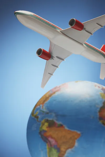 Airplane toy above globe — Stock Photo, Image