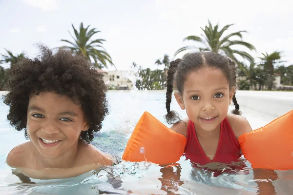 Niño y niña en la piscina — Foto de Stock