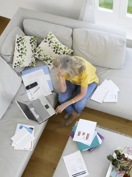 Woman using laptop on sofa — Stock Photo, Image
