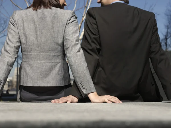 Homem de negócios e mulher sentados — Fotografia de Stock