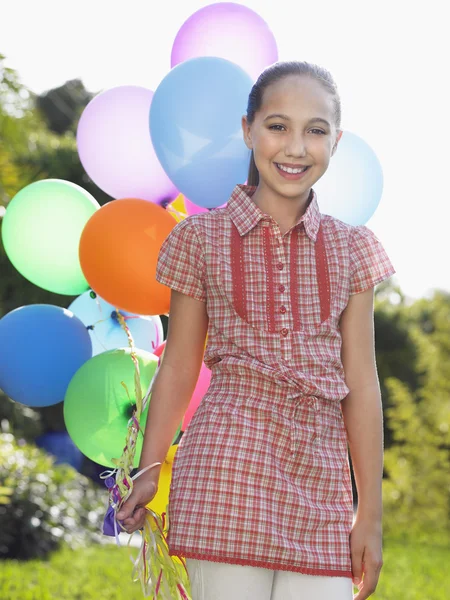 Flicka med ballonger leende — Stockfoto