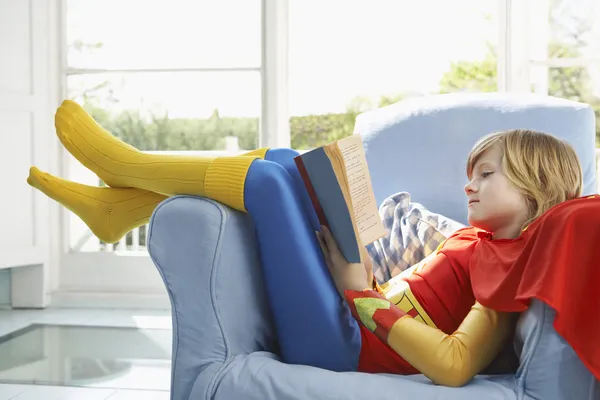 Boy  reading in armchair — Stock Photo, Image