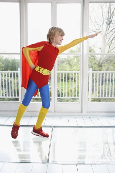 Junge im Superheldenkostüm mit ausgestrecktem Arm — Stockfoto