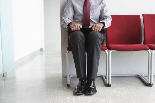 Man waiting on chair in corridor