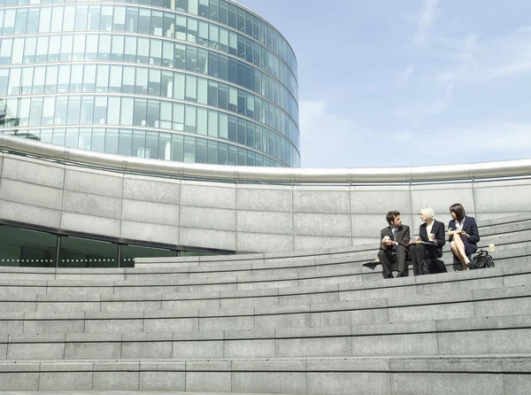 Empresários sentados nas escadas — Fotografia de Stock
