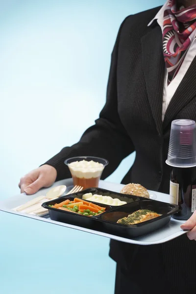 Stewardess hält Tablett mit Lebensmitteln — Stockfoto