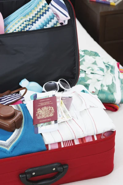 Open suitcase on bed — Stock Photo, Image