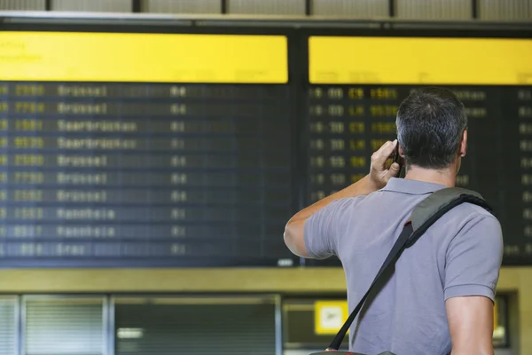 Человек в аэропорту с помощью мобильного телефона — стоковое фото