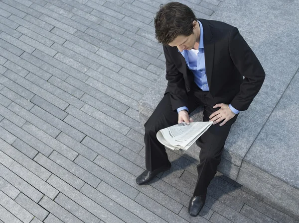 Businessman sitting on wall — Stock Photo, Image