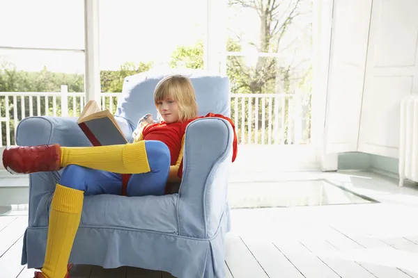 Niño leyendo en sillón — Foto de Stock