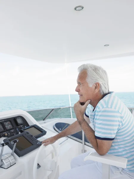 Man sitting at helm of yacht — Stock Photo, Image