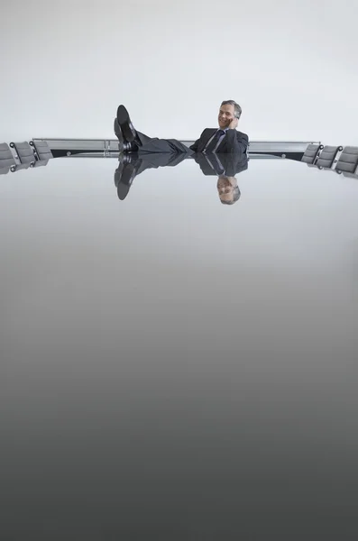 Hombre de negocios con los pies en la mesa — Foto de Stock