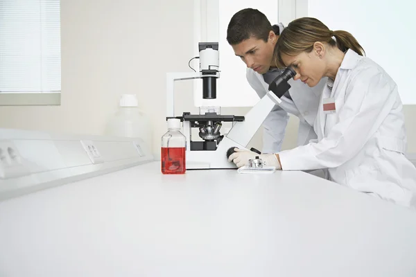 Técnicos usando microscopio — Foto de Stock