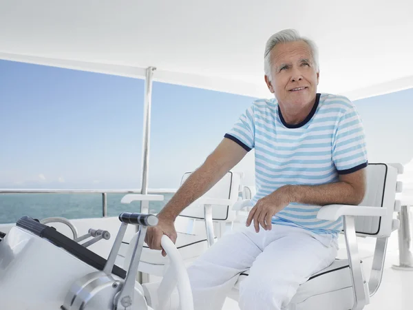 Man sitting at helm of yacht — Stock Photo, Image