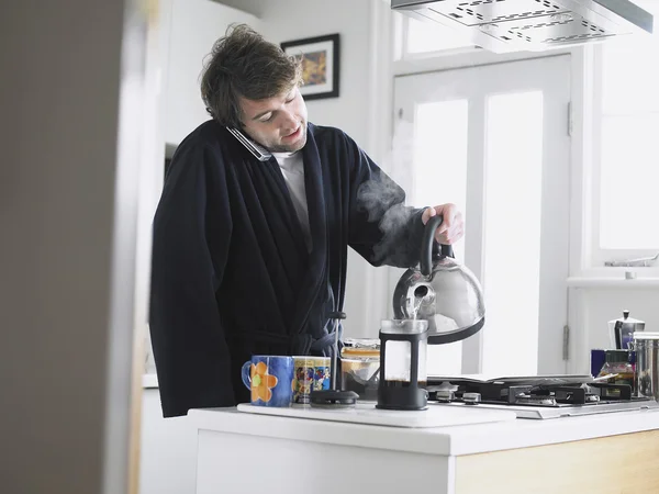Mann benutzt Telefon in Küche mit Kaffee — Stockfoto