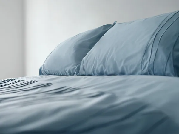 Кровать с синим бельем — стоковое фото