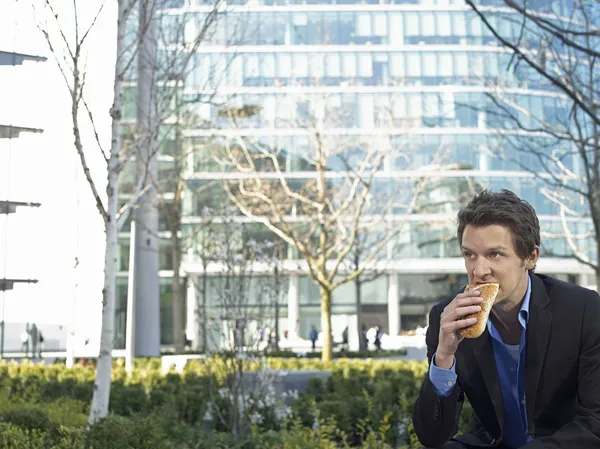 Empresário comendo sanduíche — Fotografia de Stock