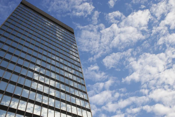 Ουρανό και τα σύννεφα που αντανακλούν σε ουρανοξύστη — Φωτογραφία Αρχείου