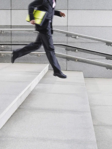 Business man running down steps — Stock Photo, Image