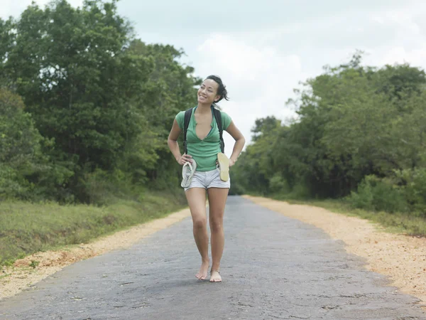 Woman barefoot walking on rural road — Stock Photo, Image